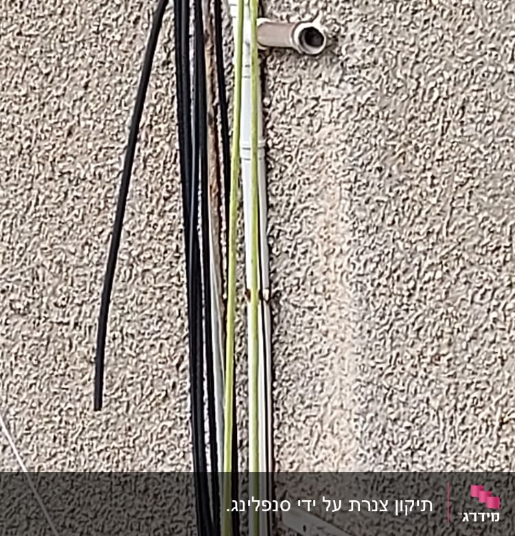 צינור מתכת בולט מקיר עם כבלים צמודים